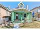 Charming green home featuring a peaked roof and welcoming front porch at 4054 Wyandot St, Denver, CO 80211