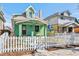 Charming green home boasting a peaked roof and a classic white picket fence at 4054 Wyandot St, Denver, CO 80211