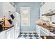 Galley kitchen with white cabinets, sleek black countertops, a gas range, and blue and white checkerboard floors at 4054 Wyandot St, Denver, CO 80211