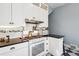 Kitchen featuring white cabinets, stainless steel appliances, black countertop, and checkerboard-patterned floor at 4054 Wyandot St, Denver, CO 80211