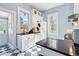 Bright kitchen with black countertops, crisp white cabinetry, a blue checkerboard floor, and natural light at 4054 Wyandot St, Denver, CO 80211