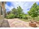 Stone patio with fire pit overlooks lush backyard with manicured landscaping and unobstructed views at 5131 Netherland St, Denver, CO 80249