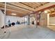 Unfinished basement with exposed ceiling and gym equipment, offers potential for customization at 5131 Netherland St, Denver, CO 80249