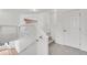 Upstairs hallway with carpeted floor, white walls, and railing with glass panel at 5131 Netherland St, Denver, CO 80249