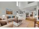 Bright, open-concept living room with soaring ceilings, hardwood floors, and seamless flow into dining and kitchen areas at 5131 Netherland St, Denver, CO 80249