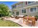 Relaxing patio area with stone flooring, a cozy seating area, outdoor dining set, and inviting fire pit at 5131 Netherland St, Denver, CO 80249
