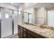 Bathroom featuring a glass shower, granite countertop, double sinks and wood cabinets at 1419 Great Western Dr, Longmont, CO 80501