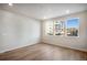 Cozy bedroom with three bright windows and wood-look flooring at 1419 Great Western Dr, Longmont, CO 80501