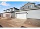 Exterior elevation of several two story townhome garages with gravel landscaping and driveways at 1419 Great Western Dr, Longmont, CO 80501