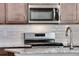 Close-up of a modern kitchen featuring stainless steel appliances, granite countertops, and white tile backsplash at 1419 Great Western Dr, Longmont, CO 80501