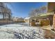 Snowy backyard with wooden fence, shed, and covered patio at 68 W 81St Pl, Denver, CO 80221