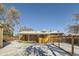 Brick home backyard with fence, covered patio, and snowy ground at 68 W 81St Pl, Denver, CO 80221