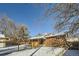 Brick home backyard with snow, wooden fence, and covered patio at 68 W 81St Pl, Denver, CO 80221