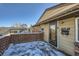 Front entrance with wooden deck and snow on the ground at 68 W 81St Pl, Denver, CO 80221