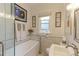 Bathroom featuring a tub, modern fixtures, and neutral-toned tile at 1434 Osceola St, Denver, CO 80204