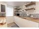 Basement kitchen offering butcher block countertops, stainless steel appliances, and open shelving at 1434 Osceola St, Denver, CO 80204