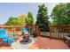 Outdoor deck with comfortable blue seating, fire pit, grill, and lovely green trees for shade at 527 English Sparrow Trl, Highlands Ranch, CO 80129