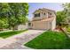 Well-manicured lawn and a long driveway leading to this two-story home with neutral siding at 527 English Sparrow Trl, Highlands Ranch, CO 80129