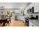 Well-lit kitchen featuring white cabinets, granite countertops, and sliding glass door to the deck at 527 English Sparrow Trl, Highlands Ranch, CO 80129
