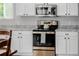 Kitchen with stainless steel oven and microwave, complemented by white cabinets and granite countertops at 527 English Sparrow Trl, Highlands Ranch, CO 80129