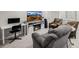 Inviting living room with fireplace, comfy chairs, desk, tv and grey sofas perfect for relaxing at 527 English Sparrow Trl, Highlands Ranch, CO 80129
