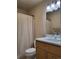 Clean bathroom featuring a modern vanity, toilet, and shower with light colored shower curtain at 9105 E Lehigh Ave # 105, Denver, CO 80237