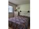 Cozy bedroom with paneled headboard, a dresser and a sun-filled window at 9105 E Lehigh Ave # 105, Denver, CO 80237