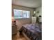 Comfortable bedroom with a bright window, dresser, and warm lighting at 9105 E Lehigh Ave # 105, Denver, CO 80237