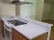Stylish kitchen features white marble-style countertops, wood cabinets, and sleek electric cooktop at 9105 E Lehigh Ave # 105, Denver, CO 80237