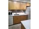 Modern kitchen with updated marble-style countertops, wooden cabinets and stainless steel appliances at 9105 E Lehigh Ave # 105, Denver, CO 80237