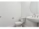Clean bathroom with a pedestal sink, round mirror, and modern toilet at 8245 Cokedale Cir, Littleton, CO 80125