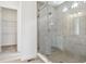 Modern bathroom showcasing a tiled walk-in shower with glass doors, alongside a glimpse into a closet at 8245 Cokedale Cir, Littleton, CO 80125