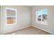 A carpeted bedroom with natural light, featuring two windows and neutral wall color at 5913 Sawdust Dr, Brighton, CO 80601