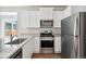 Modern kitchen featuring stainless steel appliances, granite countertops and white cabinets at 5913 Sawdust Dr, Brighton, CO 80601