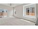Bright living room with ceiling fan, sliding glass door and carpeted floors at 5913 Sawdust Dr, Brighton, CO 80601