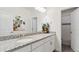 Bathroom with double granite vanity, sleek white cabinets, and a view into a tiled shower at 953 Compass Dr, Erie, CO 80516