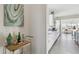 Open hallway showcasing modern white cabinetry, stainless steel appliances, and a view of the kitchen at 953 Compass Dr, Erie, CO 80516