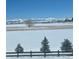 Scenic mountain views from a beautiful homesite with snow-covered ground and mature trees on the property at 953 Compass Dr, Erie, CO 80516