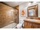 Bathroom features a glass-enclosed shower, wood vanity, and earth-toned tile at 46093 Bristlecone Ct, Parker, CO 80138