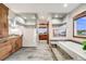 Bright bathroom features tiled floors, a soaking tub, a walk-in shower, and custom wooden cabinets at 46093 Bristlecone Ct, Parker, CO 80138