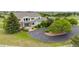 Aerial view of a two story home with an asphalt driveway surrounded by mature landscaping and expansive lawn at 46093 Bristlecone Ct, Parker, CO 80138