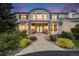 A beautiful two-story home boasts a brick entryway, blue double doors, and well-maintained landscaping at 46093 Bristlecone Ct, Parker, CO 80138