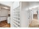 Hallway with built-in shelving leading to laundry room and stairs to upper level of home at 46093 Bristlecone Ct, Parker, CO 80138