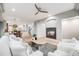 Cozy living room with fireplace, wood floors, and open floor plan to kitchen and dining area at 46093 Bristlecone Ct, Parker, CO 80138