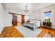 Stylish main bedroom with chandelier, wood floors, barn door to the main bathroom, and natural light at 46093 Bristlecone Ct, Parker, CO 80138