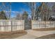 Gated entrance to community with a metal gate and wooden fence at 7725 S Cove Cir, Centennial, CO 80122