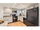 Well-equipped kitchen with white cabinets, black appliances, and subway tile backsplash at 7725 S Cove Cir, Centennial, CO 80122