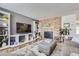 Living room featuring a brick fireplace, built-in shelving, and a large TV at 7725 S Cove Cir, Centennial, CO 80122