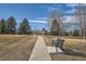 Concrete walkway winds through a park-like setting with a bench at 7725 S Cove Cir, Centennial, CO 80122