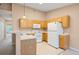 Functional kitchen with wood cabinets and white appliances, with open access to the living area at 11640 W 62Nd Pl # 203, Arvada, CO 80004